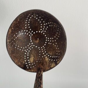 Teak slotted ladle with hippie flower pattern.
